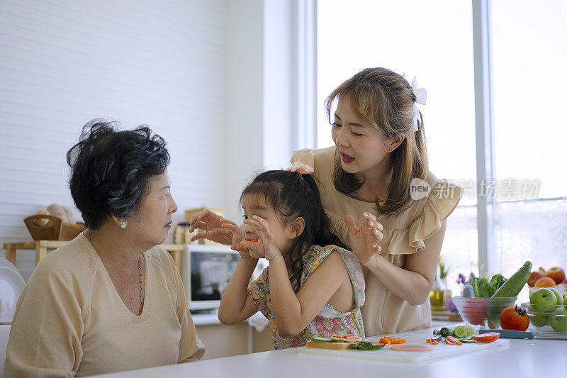 奶奶、妈妈和孙女在厨房准备食物。