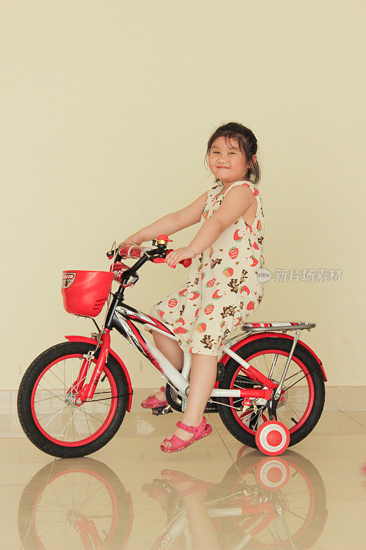 一个可爱的女婴正在骑自行车