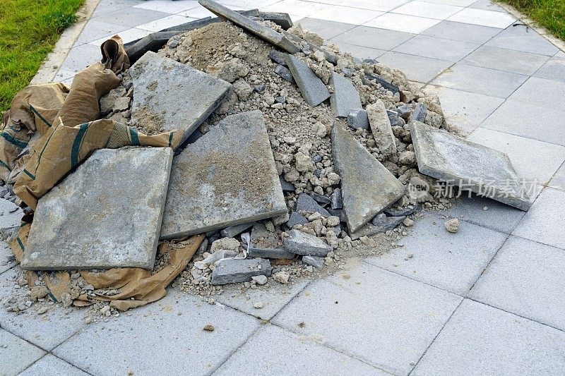 一个水泥袋上的废料，一个建筑工地上的废料，在拆除人行道上的旧瓷砖，污染环境。