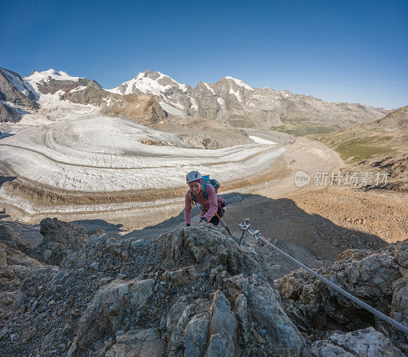 一个女人小心翼翼地走在陡峭的高山路线上