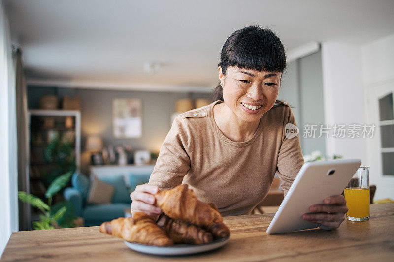 一位中年日本妇女正在用她的数码平板电脑看东西