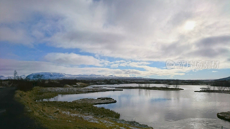 Thingvellir国家公园里的冰湖，后面是多云蓝天下的雪山