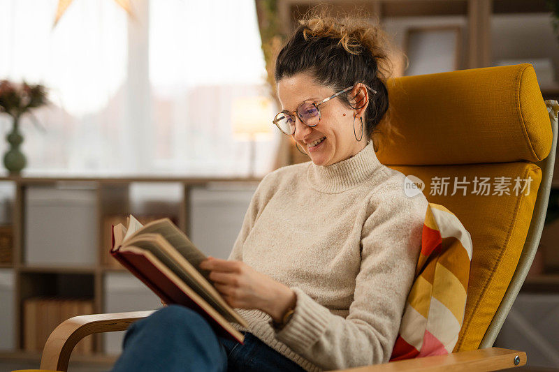 一个成年妇女在家里的客厅里看书