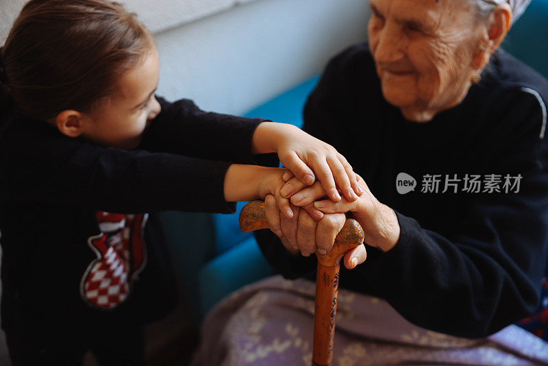 奶奶和孙女手牵着手，凑近了