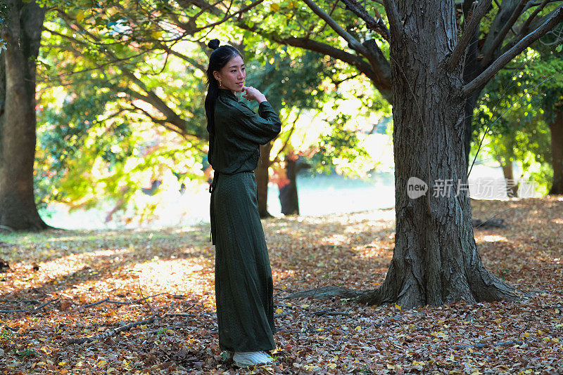 美丽的女子在秋天的森林里跳舞