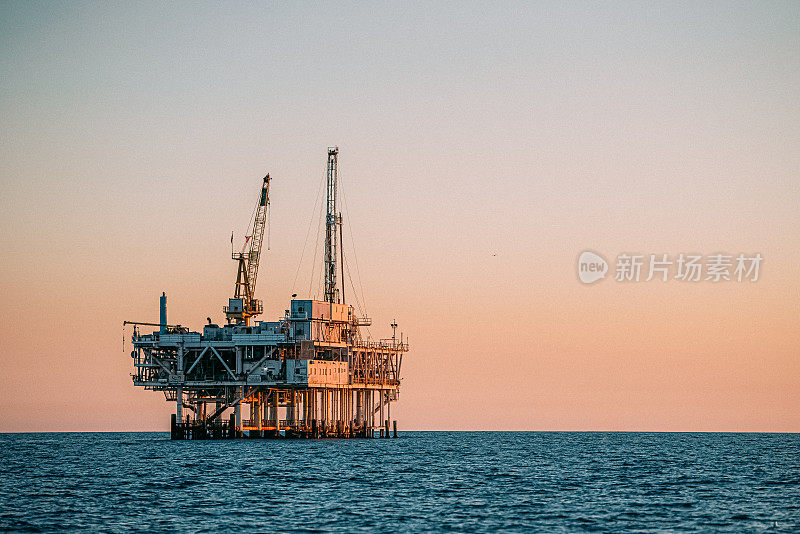 加利福尼亚州亨廷顿海滩日落处的海上石油钻井平台