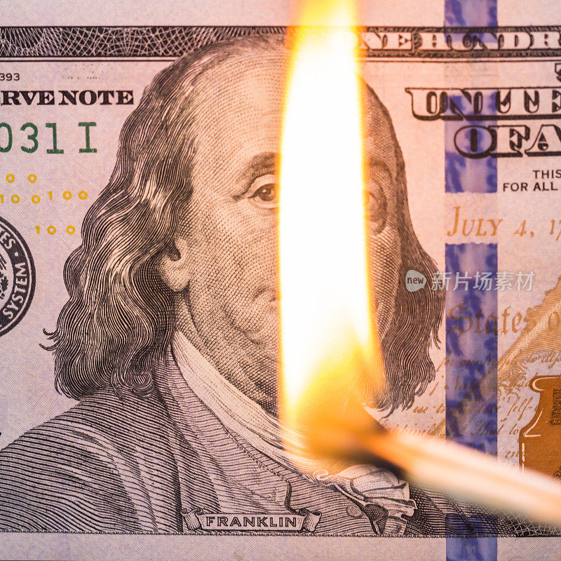 100美元纸币和燃烧的火柴。财务问题背景。概念贬值，通货膨胀，违约，下跌