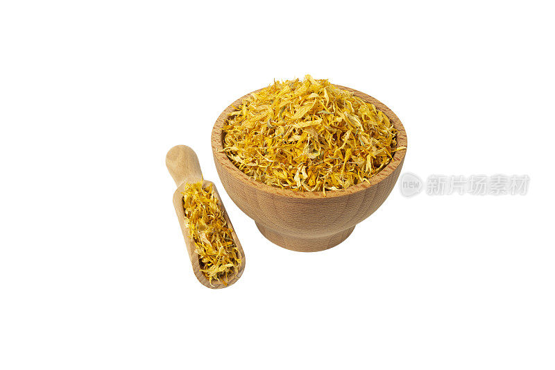 干燥的金盏菊或万寿菊花瓣装入木碗中，用勺子舀开，放在白色背景上。