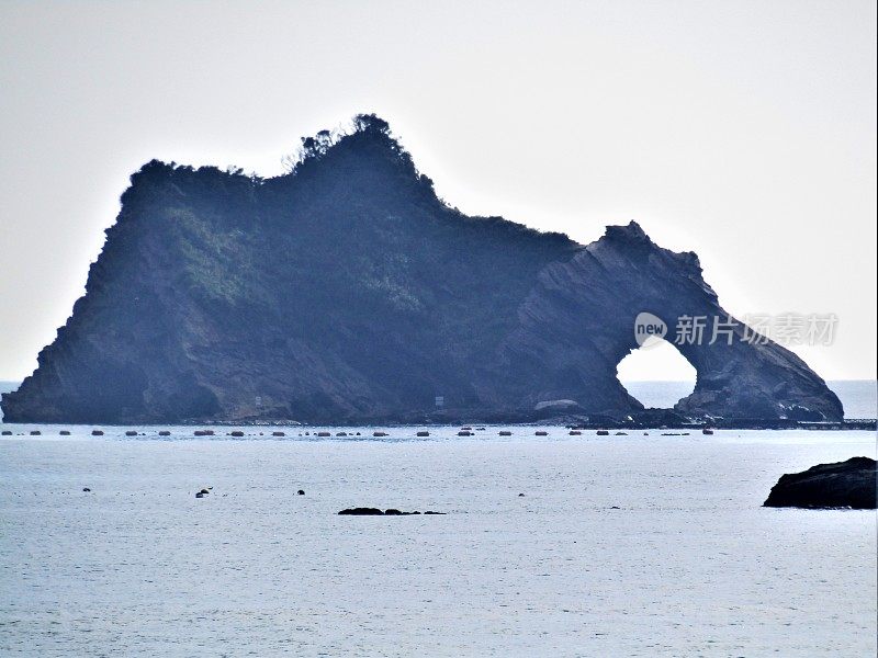 日本。岩石在海里有一个圆洞。