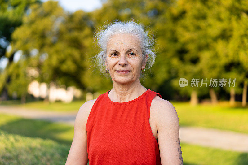 穿着红色运动服做瑜伽训练的拉丁高级妇女。老太太做健身放松运动。