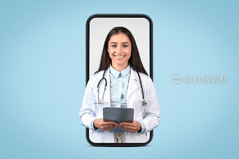 阳性的白人女医生治疗师穿着白大褂拿着药片，手机屏幕大，蓝色背景孤立