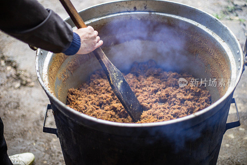 厨师在大锅里煮猪油，这是传统的烹饪方法