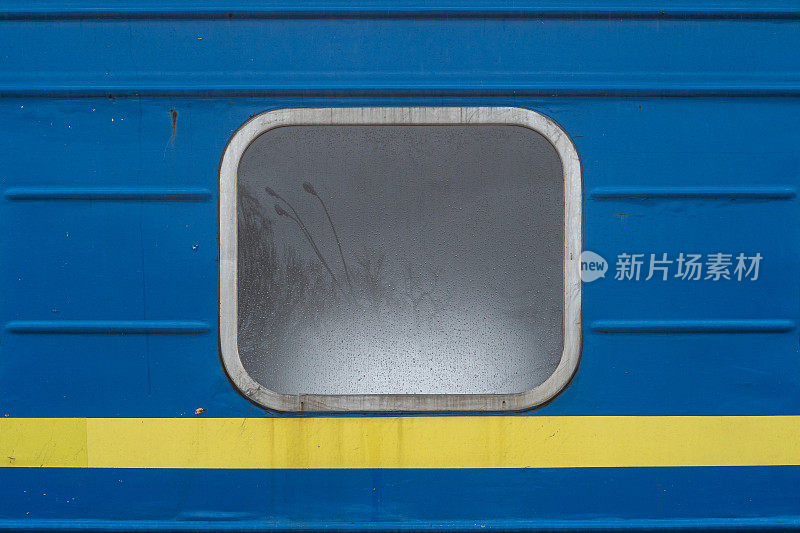 一列火车的蓝色客车的窗户，下面有一条黄色的条纹。
