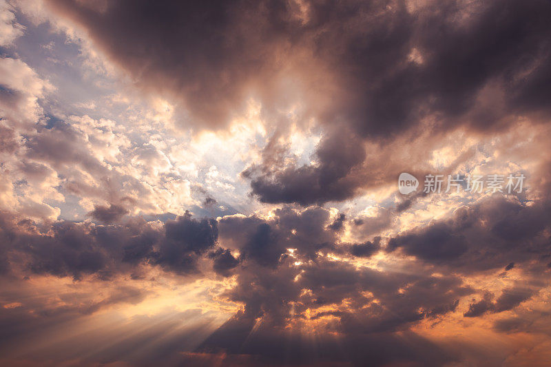 戏剧性的日落天空背景:阳光穿透黑色雷云