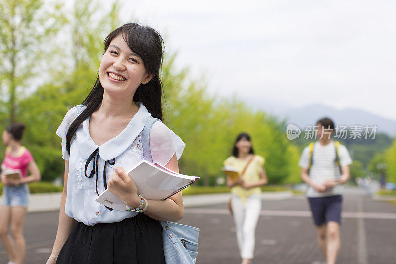 微笑的女大学生走在校园里