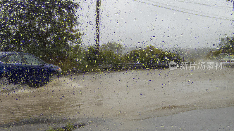 车窗上的雨水淹没了汽车行驶的道路