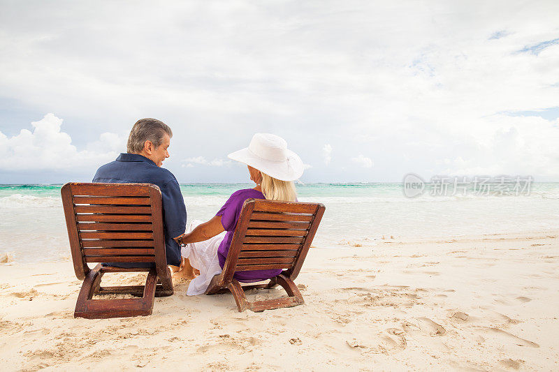 快乐的老年夫妇一边放松一边看海