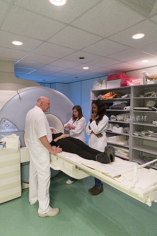 女患者进行核磁共振扫描，协助放射科主任，两名医生