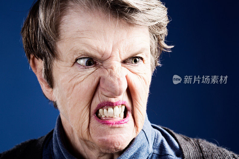 离我远点!愤怒而紧张的老妇人做了个鬼脸