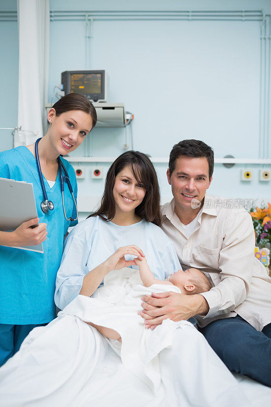 医生和父母抱着一个穿着尿布的男婴