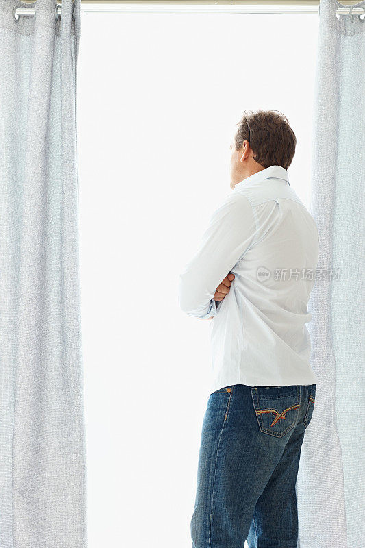 一个成熟男人透过窗户看的后视图