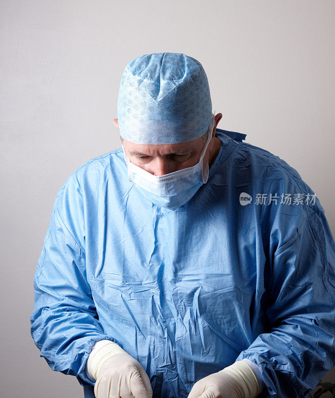外科医生穿着无菌手术服准备手术