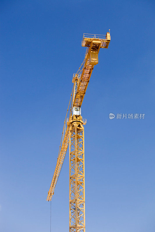 大型黄色建筑起重机对抗晴朗的蓝天