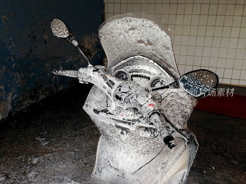 摩托车的特写是在车库用泡沫清洗