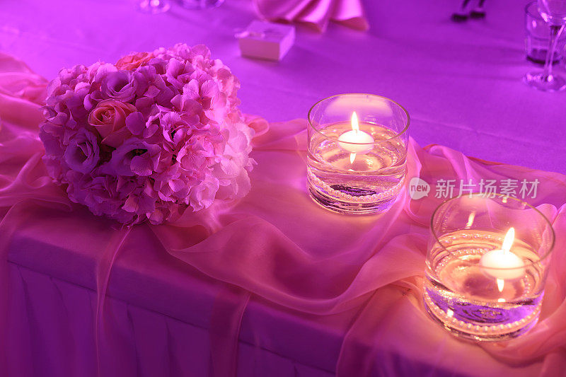 紫色的婚宴餐桌装饰，玫瑰花束和蜡烛