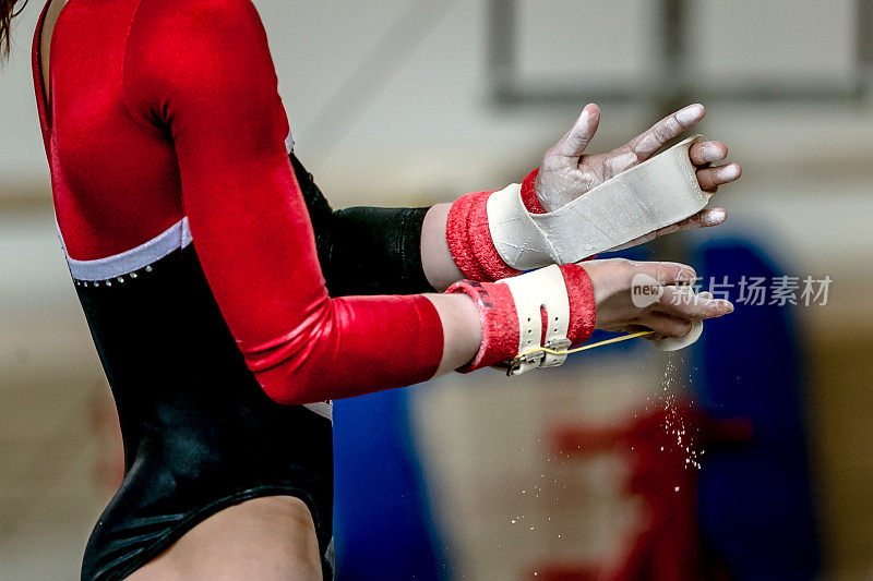 体操运动员在单杠上表演前紧握女孩的手