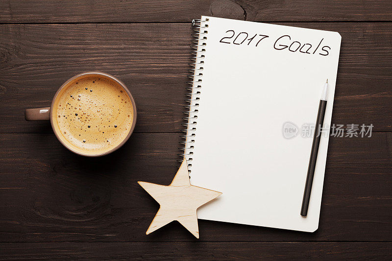 咖啡和笔记本上写着2017年的目标。规划和动机。