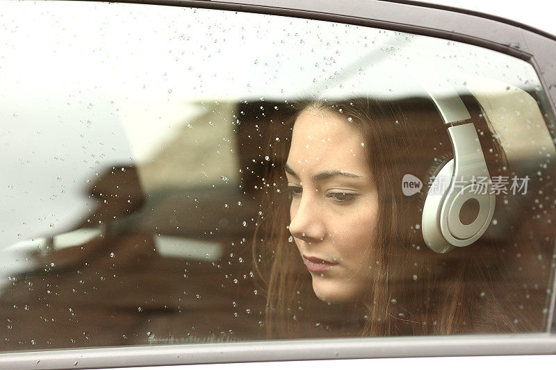 一个戴着耳机坐在车里的悲伤少女