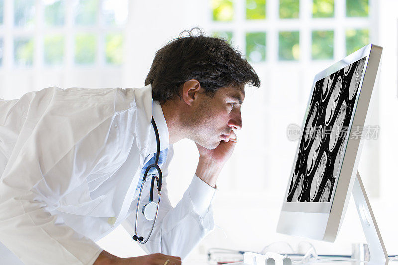 容男医生正在看人体腹部的CAT扫描图像