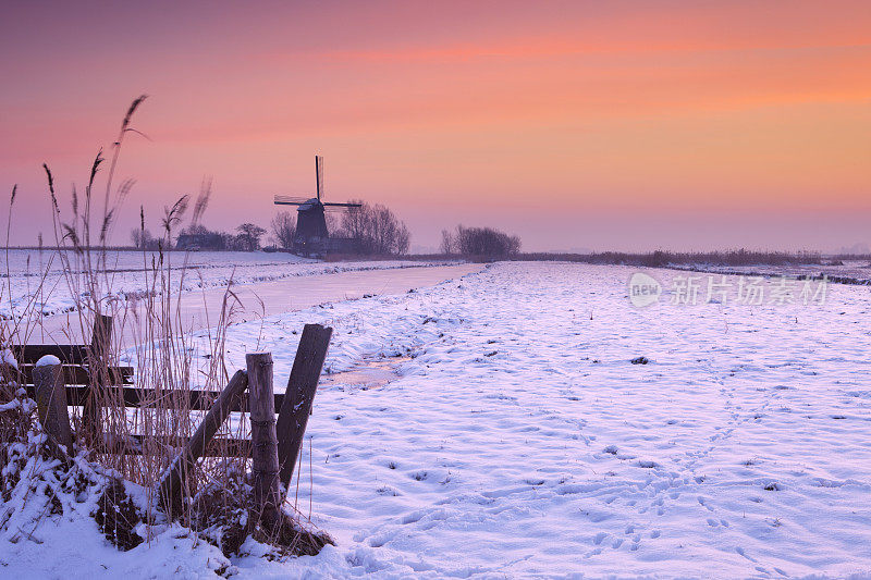 传统的荷兰风车在冬天日出
