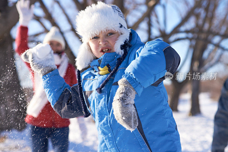 愤怒的小男孩在扔雪球