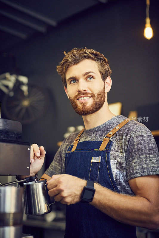 微笑的咖啡师使用蒸笼的咖啡机