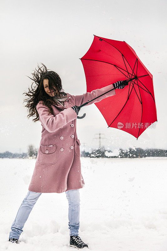 有风的冬天，年轻的女性撑着伞