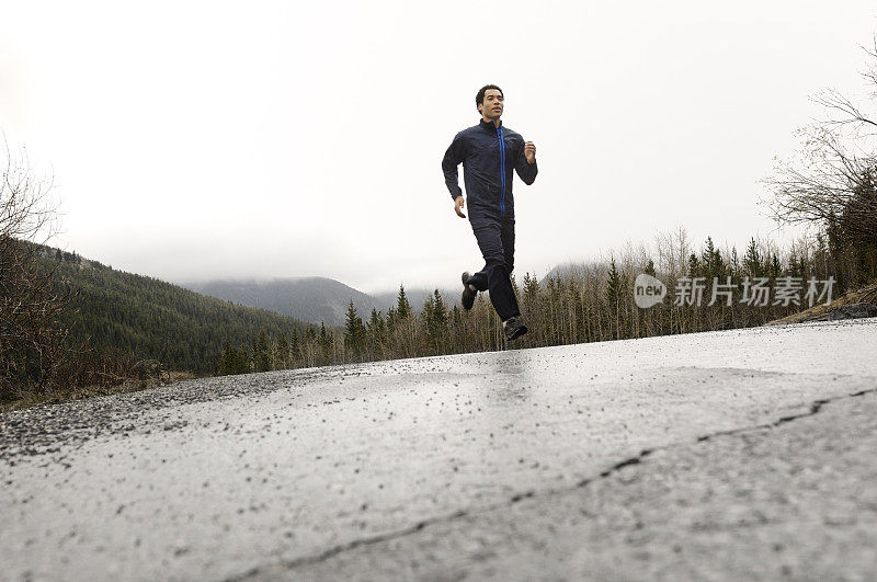 运动员在下雨的山路上跑步