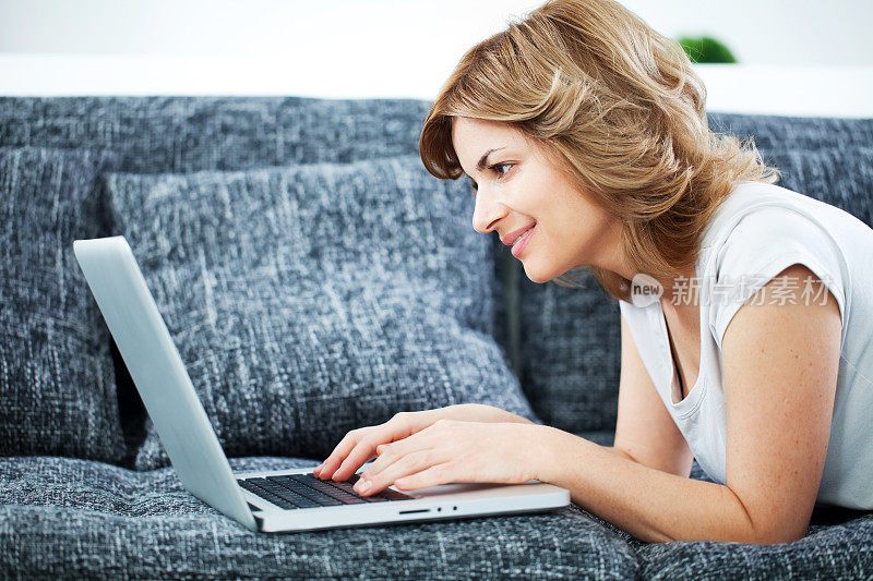 女人在家里通过笔记本电脑休息和工作。