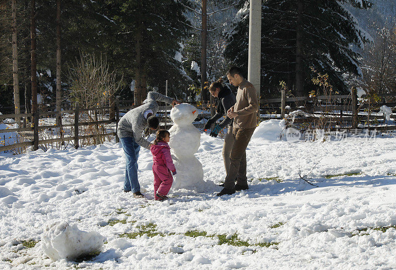 快乐的一家人堆雪人。