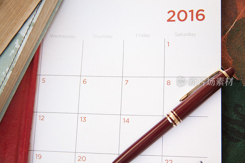 钢笔和空白的2016日历页。
