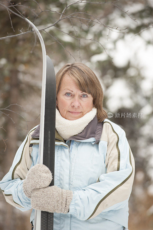 成熟的女人在冬天和滑雪板。