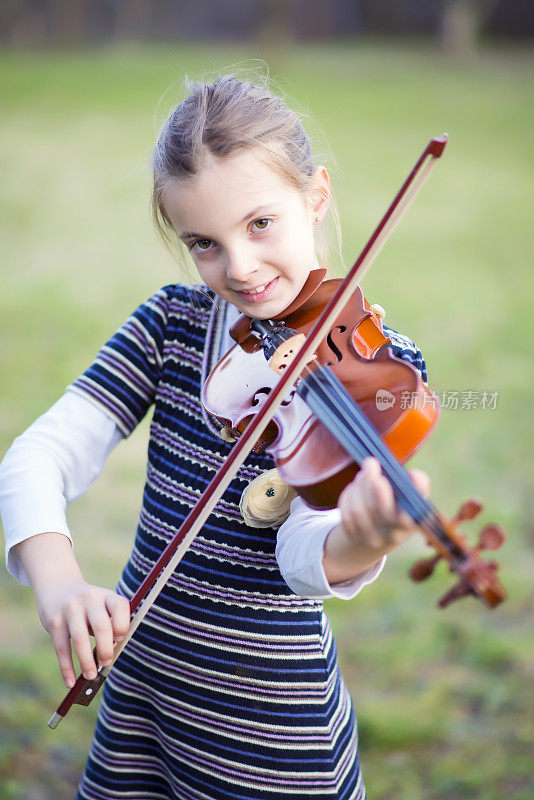 年轻女孩学习拉小提琴的肖像