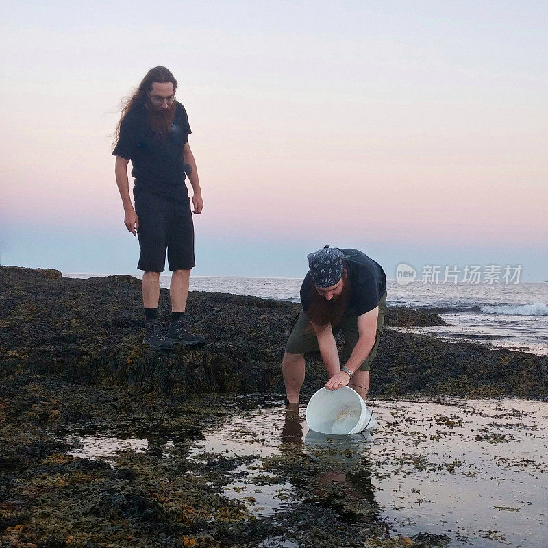 两个人取龙虾，煮海水，大桶