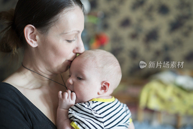 年轻的母亲，手上抱着六个月大的女儿。