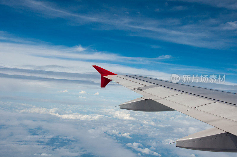 在飞机上看窗外的时候。你可以看到天空和飞机机翼的云彩。-概念云，飞机，天空。