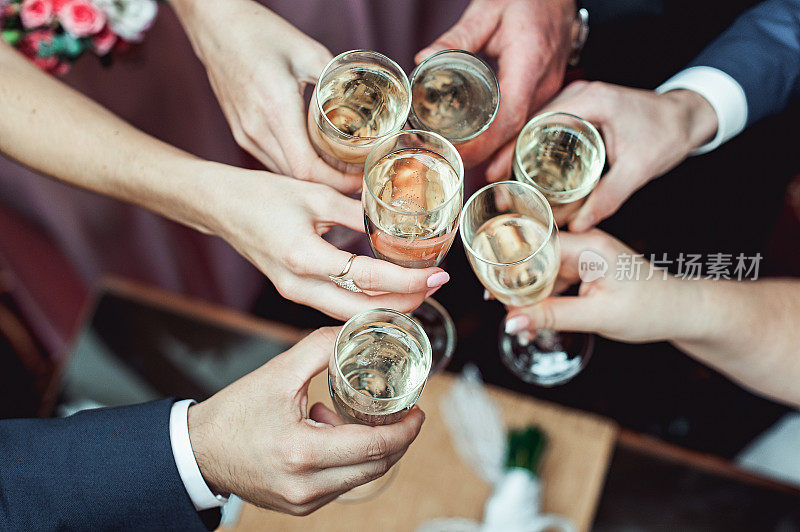 人们手里拿着盛着白葡萄酒的玻璃杯。婚礼。