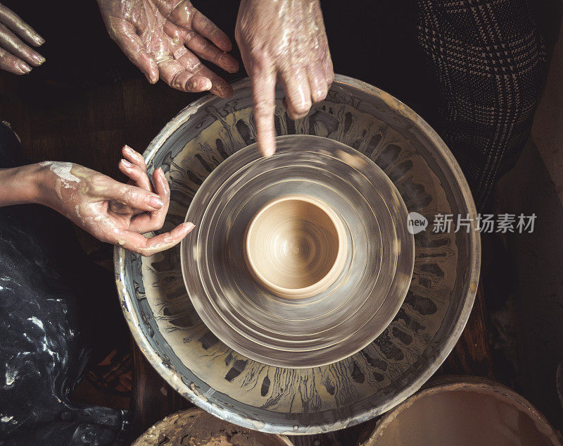 陶工大师的双手和陶工转盘上的陶土花瓶