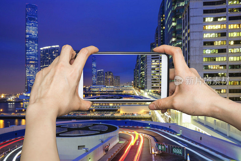 日落时分，香港夜景交通中，女孩用手机拍照