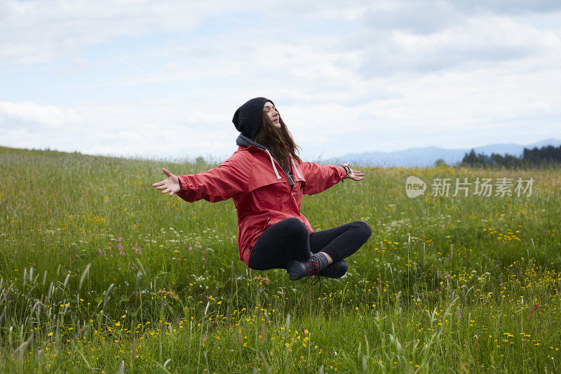 神奇的自然界中。在草地上飘浮的女人